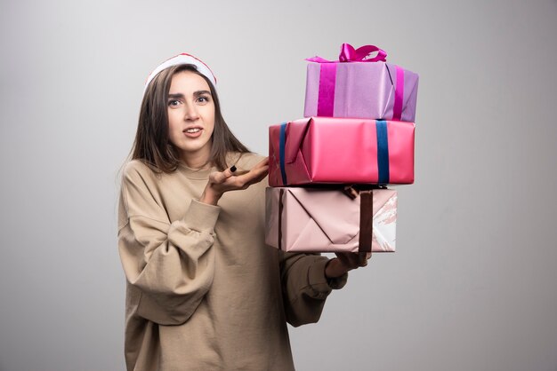 Jeune femme tenant trois boîtes de cadeaux de Noël.