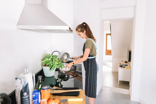 Photo gratuite jeune femme tendant des pâtes bouillies dans l'évier