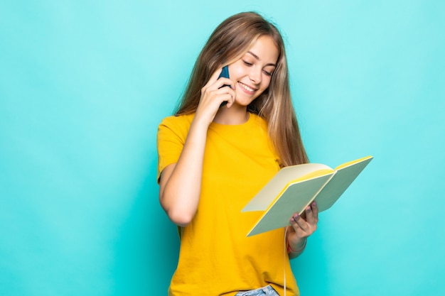 Jeune femme tenir planificateur écrire des secrets privés dans le journal mur turquoise isolé