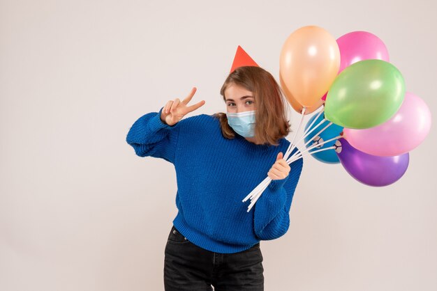 jeune femme, tenue, ballons colorés, dans, masque, blanc