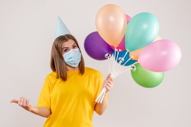 jeune femme, tenue, ballons colorés, dans, masque, blanc