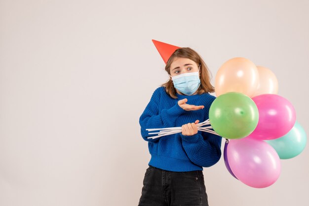 jeune femme, tenue, ballons colorés, dans, masque, blanc