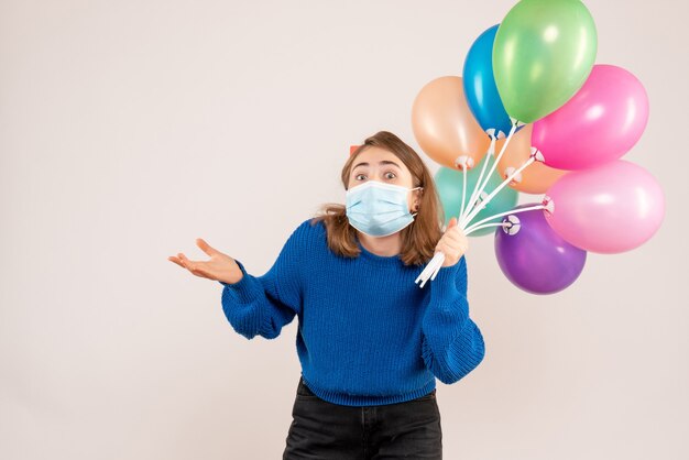 jeune femme, tenue, ballons colorés, dans, masque, blanc