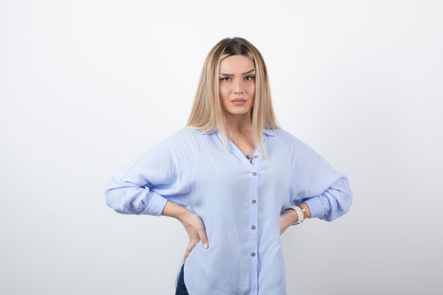 Jeune femme en tenue décontractée regardant la caméra sur fond blanc.