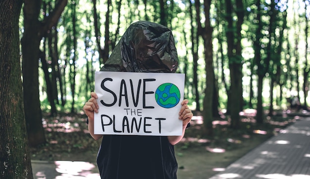 Une jeune femme tient une affiche avec un appel à sauver la planète