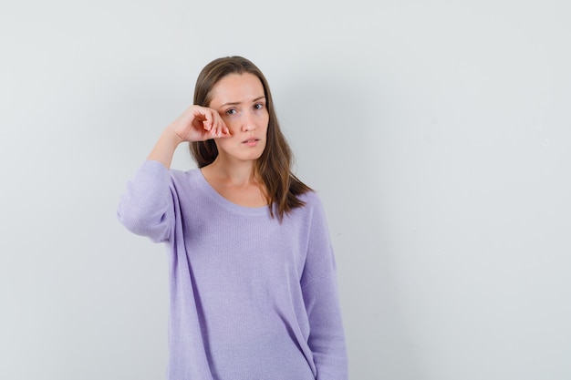 Jeune femme touchant sa peau sur la joue en chemise décontractée et à la jolie