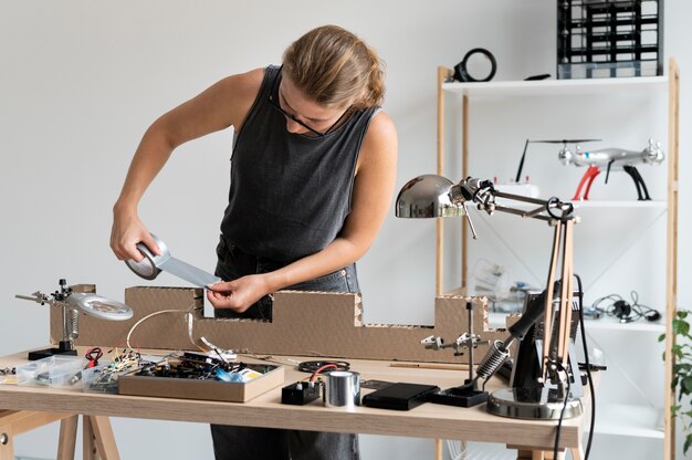 Jeune femme travaillant dans son atelier pour une invention créative