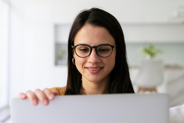 Jeune femme travaillant sur son ordinateur portable à la maison