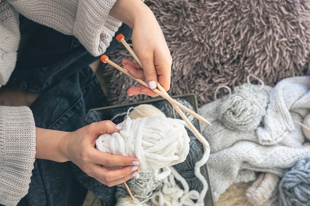 Photo gratuite une jeune femme tricotant un pull chaud à la maison