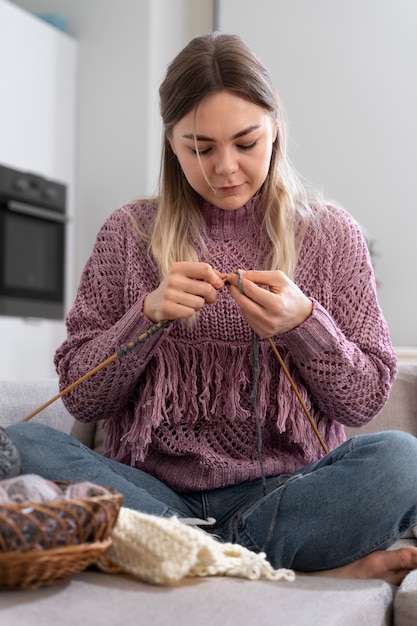 Jeune femme tricotant tout en se relaxant