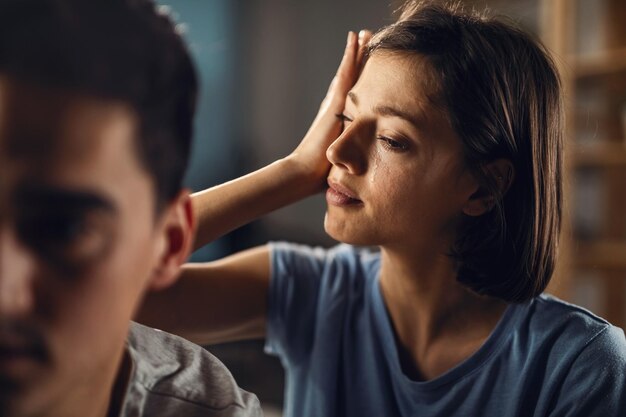 Jeune femme triste essuyant ses larmes tout en ayant des problèmes dans une relation avec son petit ami