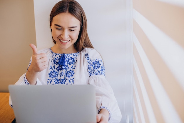 Photo gratuite jeune femme ukrainienne portant du vyshyvanka travaillant à domicile