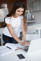 Jeune femme utilisant un ordinateur portable pour acheter de nouveaux trucs de geek sur la vente du cyber lundi pour son petit ami