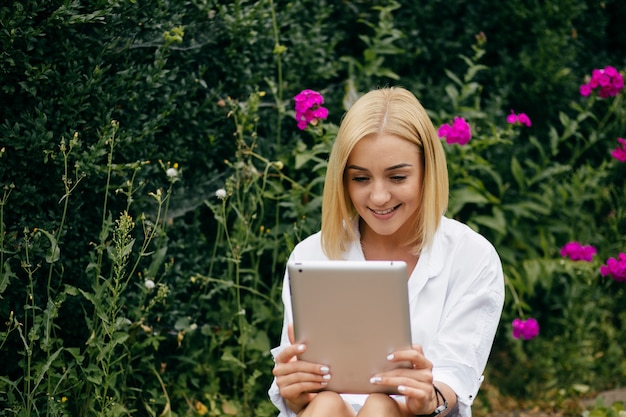 Jeune femme utilisant un ordinateur portable et un téléphone intelligent. Belle étudiante travaillant sur ordinateur portable en plein air