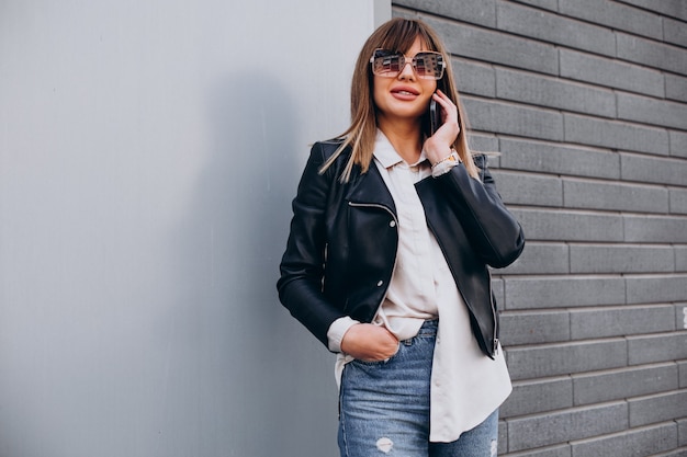 Jeune femme utilisant le téléphone par le centre commercial