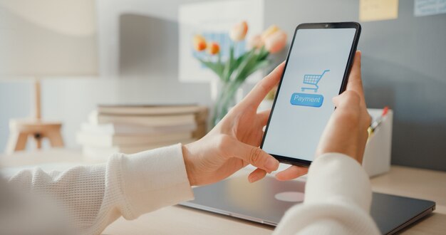 Une jeune femme utilise un produit d'achat en ligne pour commander un téléphone portable et paie des factures avec une application bancaire avec une transaction réussie. Restez à la maison, Activité de quarantaine, Activité amusante pour la prévention des coronavirus.