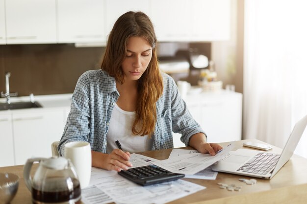 Jeune femme vérifiant son budget et faisant des impôts