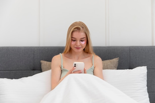 Photo gratuite jeune femme vérifiant son smartphone