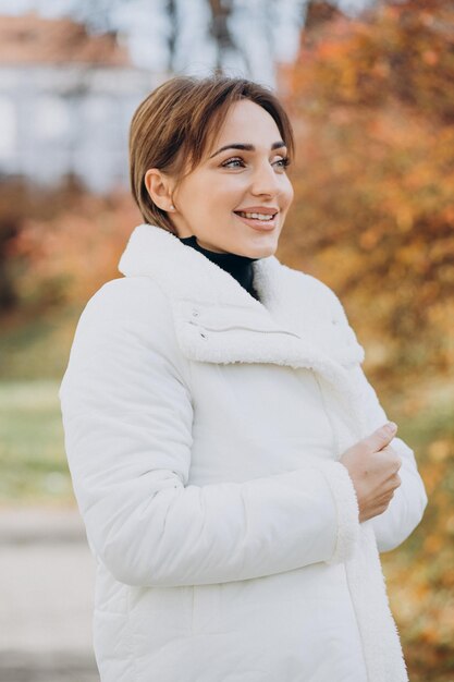 Jeune femme en veste blanche à l'extérieur