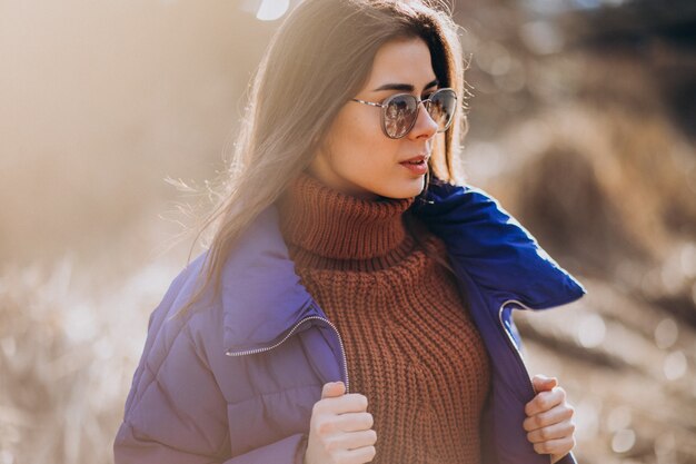 Jeune femme en veste bleue à l'extérieur dans le parc