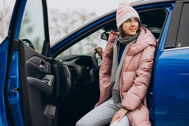 Jeune femme en veste d'hiver assise dans sa nouvelle voiture