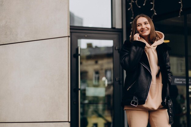 Jeune femme en veste marchant dans la rue