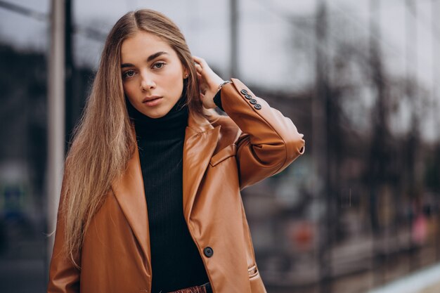 Jeune femme en veste marchant dans la ville