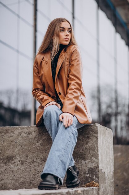 Jeune femme en veste marchant dans la ville