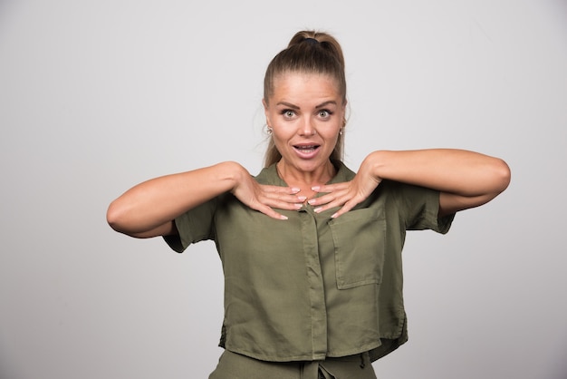 Jeune femme en veste verte se montrant.