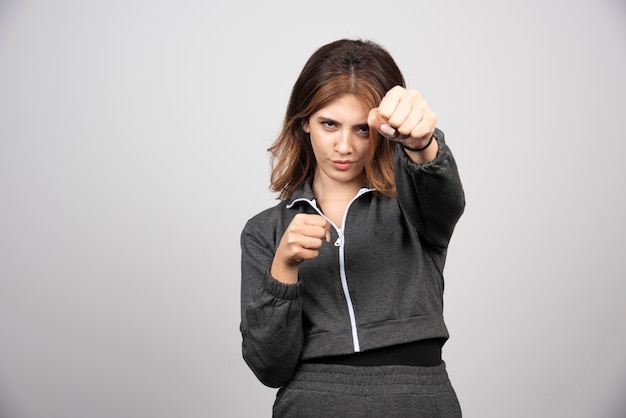 Photo gratuite jeune femme en vêtements décontractés montrant son poinçon fait à la main.