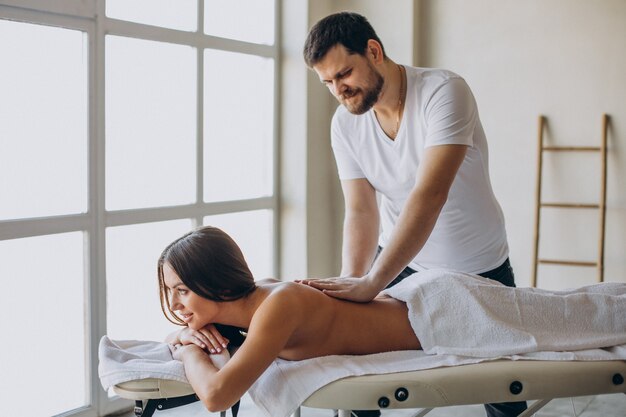 Jeune femme visitant le masseur au centre de spa