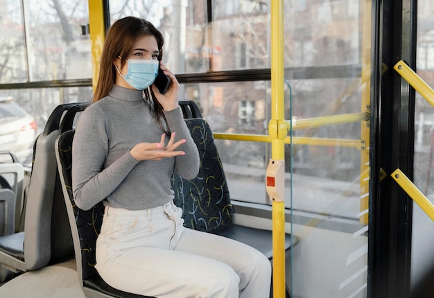 Jeune Femme Voyageant En Bus De La Ville à L'aide De Smartphone Photo gratuit