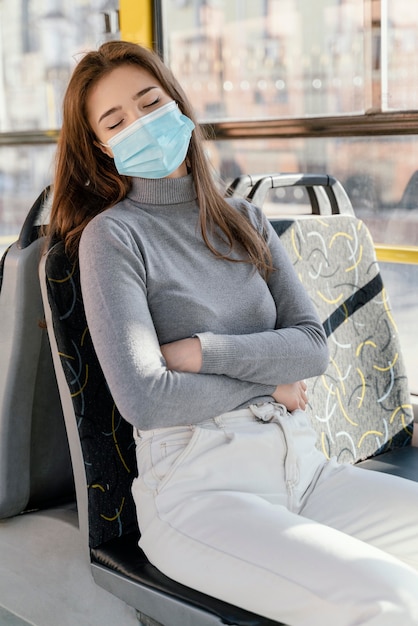 Jeune femme voyageant en bus de la ville avec masque chirurgical