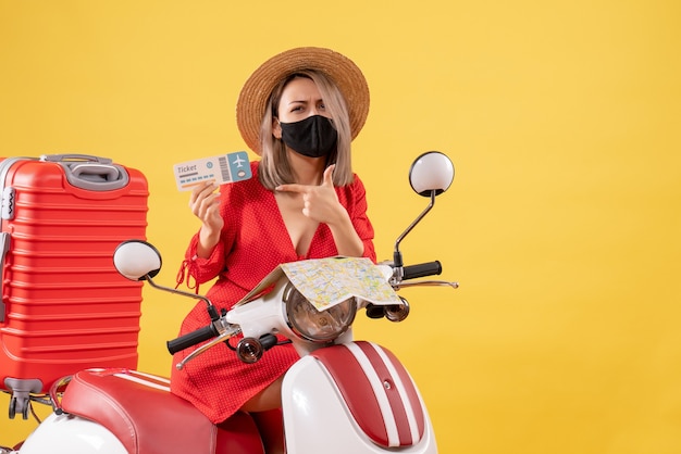 Jeune Femme Vue De Face Sur Un Cyclomoteur Avec Une Grosse Valise Tenant Un Billet