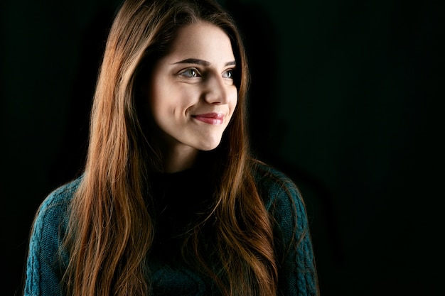 Jeune femme avec des yeux vert foncé et de longs cheveux bruns