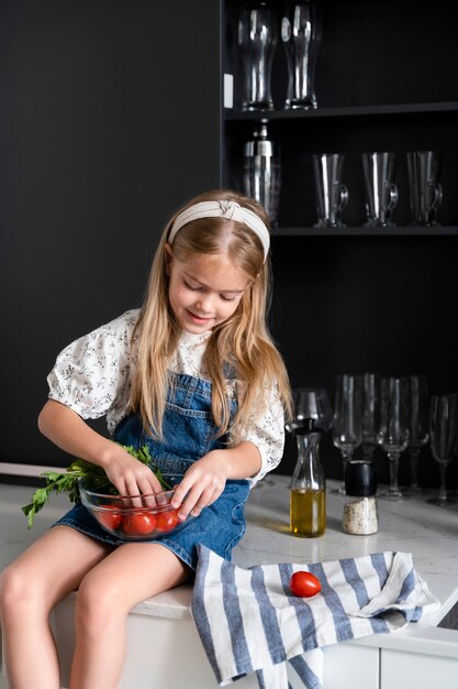 Jeune fille aidant à la cuisine