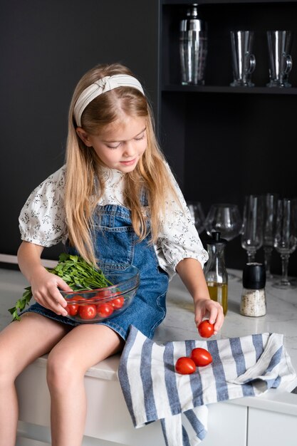 Jeune fille aidant à la cuisine