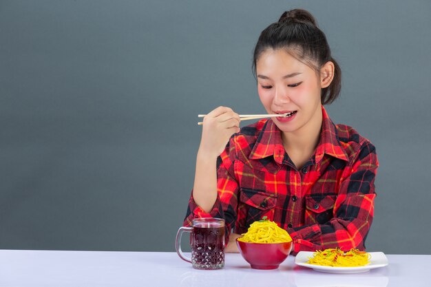 Jeune fille aime manger des spaghettis à la maison