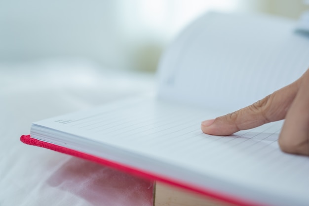 La jeune fille allongée dans son lit, écoutant de la musique et lisant des livres.