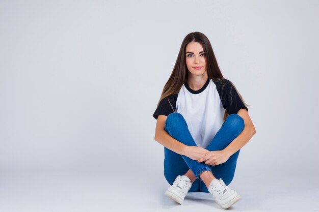 Jeune fille assise avec des jambes croisées