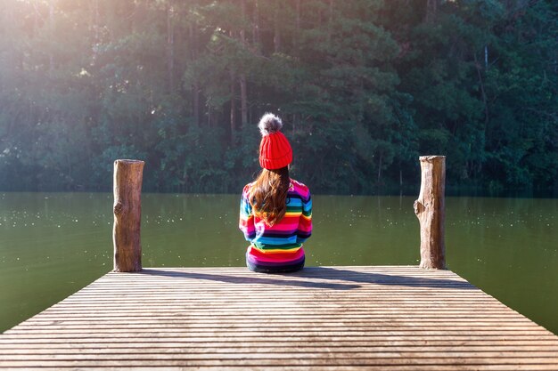 Jeune fille assise sur une jetée.