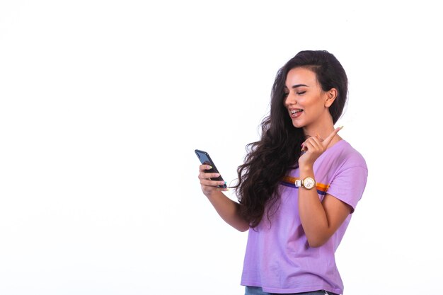 Jeune fille ayant un appel vidéo avec un smartphone noir.