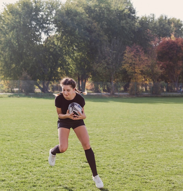 Photo gratuite jeune fille avec un ballon de rugby