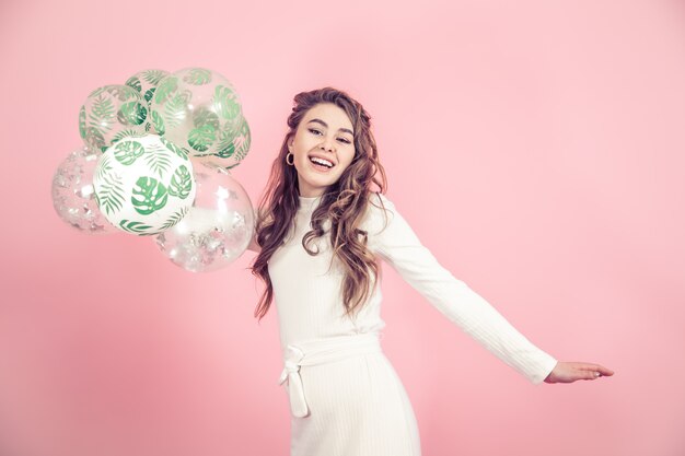 Jeune fille avec des ballons sur un mur coloré