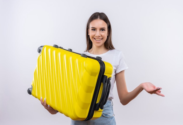 Jeune fille belle voyageur tenant valise positive et heureuse souriant gaiement