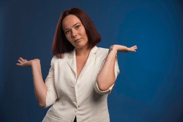 Jeune fille en blazer blanc avec les mains ouvertes.