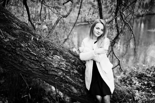 Jeune fille blonde au manteau rose posé sur le parc d'automne