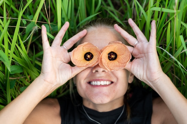 Photo gratuite jeune fille blonde souriante avec une fleur au-dessus de chaque œil