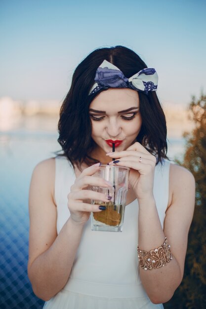 Jeune fille à boire un verre par une paille