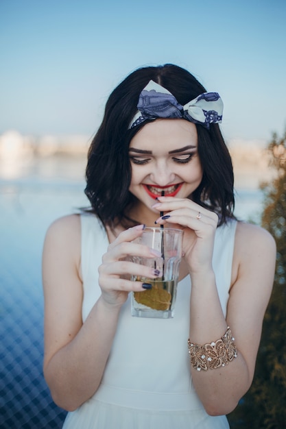 Jeune fille à boire en verre tout en souriant